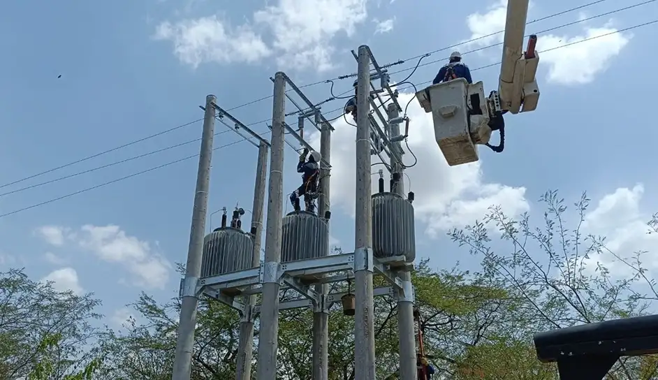 trabajadores instalando reguladores electricos con ayuda de una grua